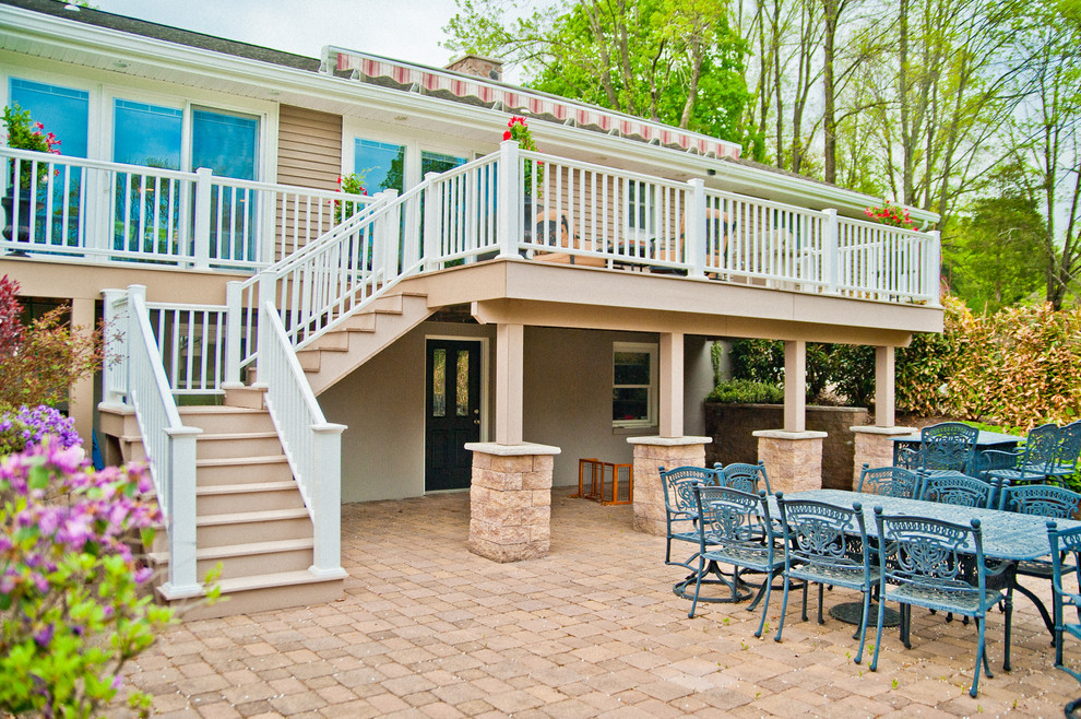 This is an example of a large traditional backyard deck in New York with an awning.
