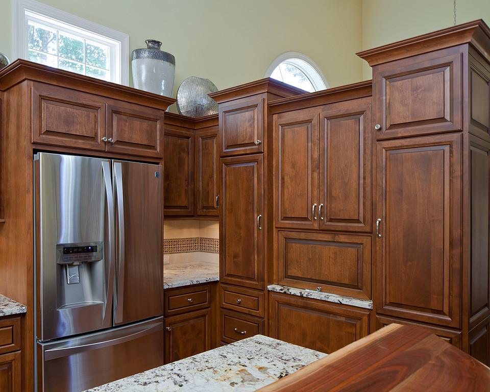 Example of a large transitional u-shaped bamboo floor open concept kitchen design in Raleigh with an undermount sink, raised-panel cabinets, dark wood cabinets, granite countertops, beige backsplash, stone tile backsplash, stainless steel appliances and an island