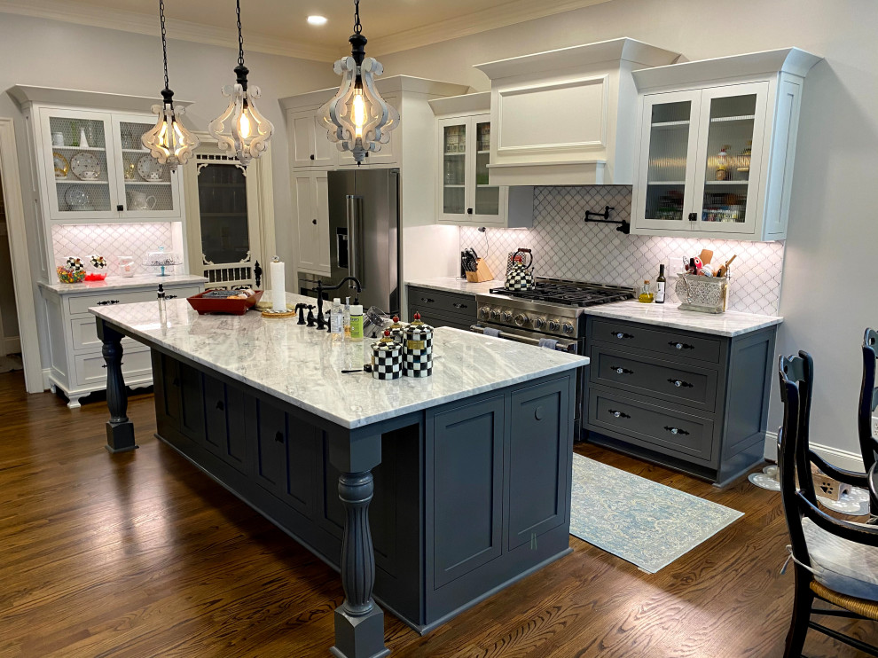 Design ideas for a mid-sized country l-shaped eat-in kitchen in Raleigh with a farmhouse sink, shaker cabinets, white cabinets, solid surface benchtops, white splashback, porcelain splashback, stainless steel appliances, dark hardwood floors, with island, brown floor and white benchtop.