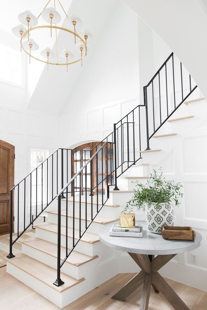 Photo of a large transitional wood l-shaped staircase in Salt Lake City with painted wood risers and metal railing.