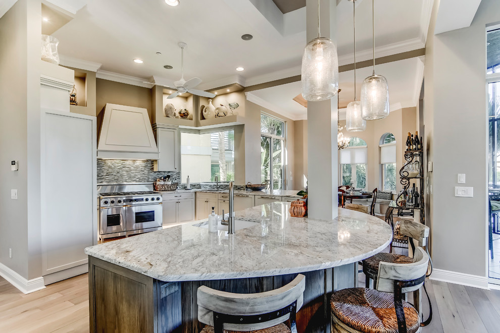 Mid-sized transitional l-shaped porcelain tile open concept kitchen photo in Miami with a drop-in sink, recessed-panel cabinets, medium tone wood cabinets, granite countertops, multicolored backsplash, glass sheet backsplash, stainless steel appliances and an island