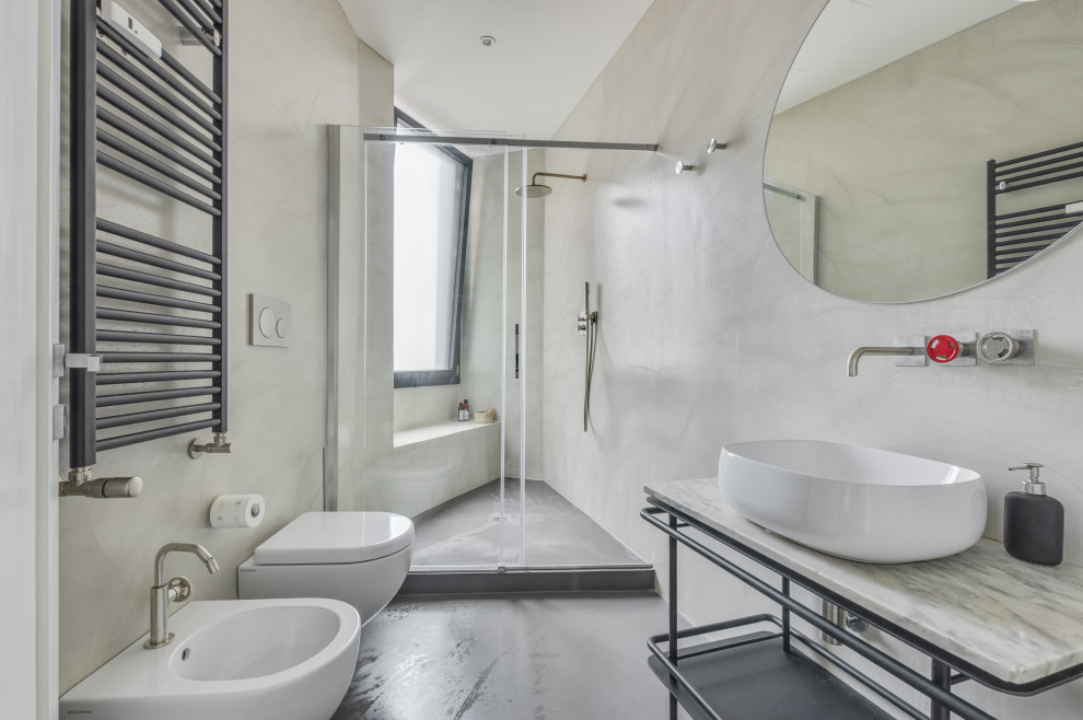 Foto på ett mycket stort industriellt badrum med dusch, med öppna hyllor, grå skåp, en vägghängd toalettstol, grå väggar, ett fristående handfat, marmorbänkskiva, grått golv och dusch med skjutdörr