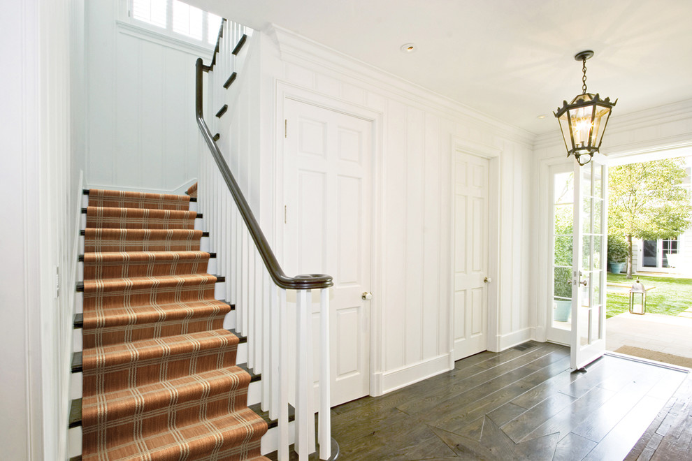 Large traditional wood u-shaped staircase in Chicago with painted wood risers.