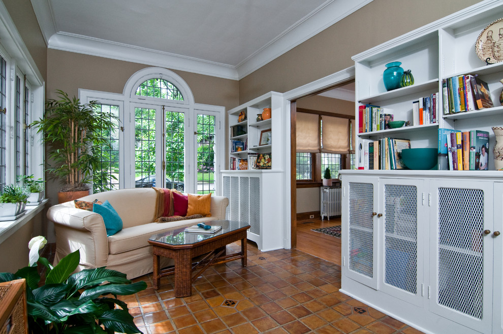 This is an example of a traditional sunroom in St Louis with terra-cotta floors, brown floor and a standard ceiling.