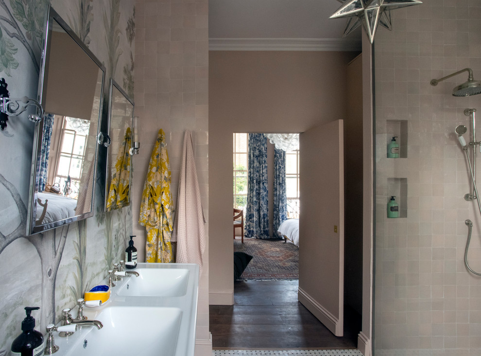Inspiration for a large contemporary ensuite bathroom in London with a freestanding bath, a walk-in shower, a wall mounted toilet, pink tiles, cement tiles, pink walls, medium hardwood flooring, a pedestal sink, double sinks and a freestanding vanity unit.