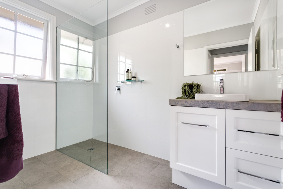 Design ideas for a mid-sized contemporary master bathroom in Melbourne with shaker cabinets, white cabinets, an open shower, white tile, ceramic tile, white walls, ceramic floors, a drop-in sink, solid surface benchtops, grey floor, an open shower and grey benchtops.