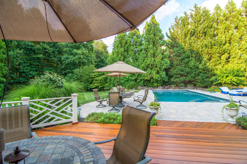 This is an example of a large traditional backyard rectangular lap pool in DC Metro with a hot tub and decking.