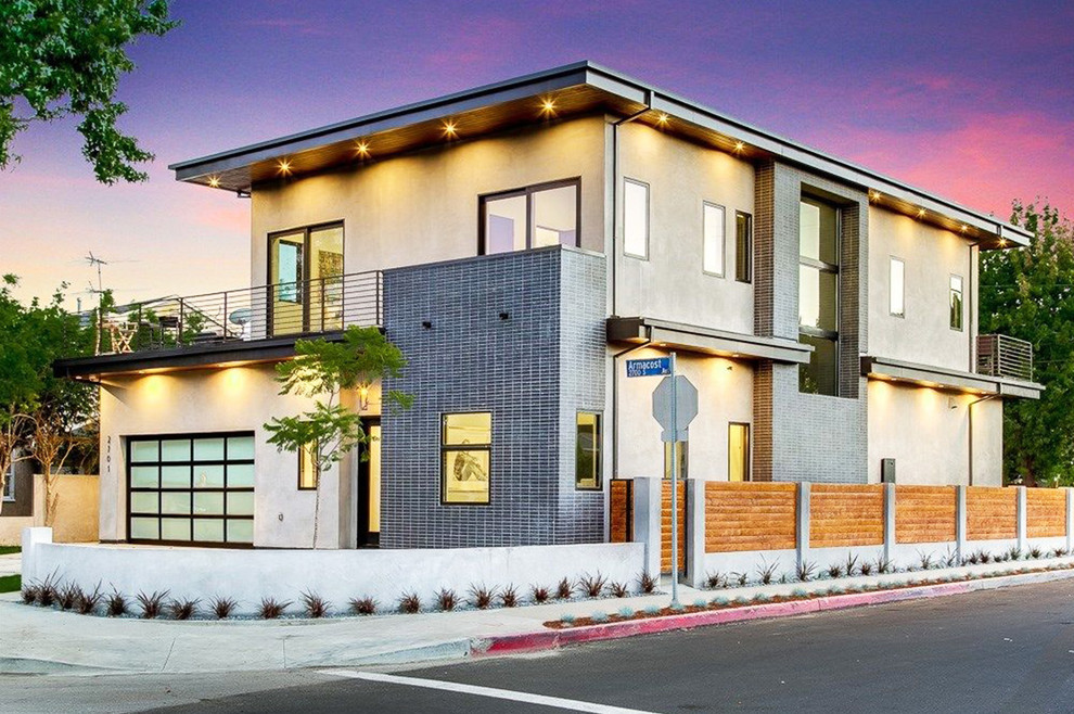 Design ideas for a mid-sized contemporary two-storey stucco beige house exterior in Los Angeles with a flat roof.