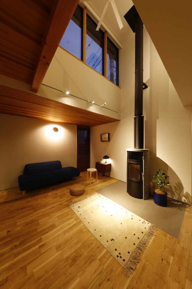 This is an example of a modern living room in Other with white walls, medium hardwood flooring, a wood burning stove, a tiled fireplace surround, a wood ceiling and wallpapered walls.