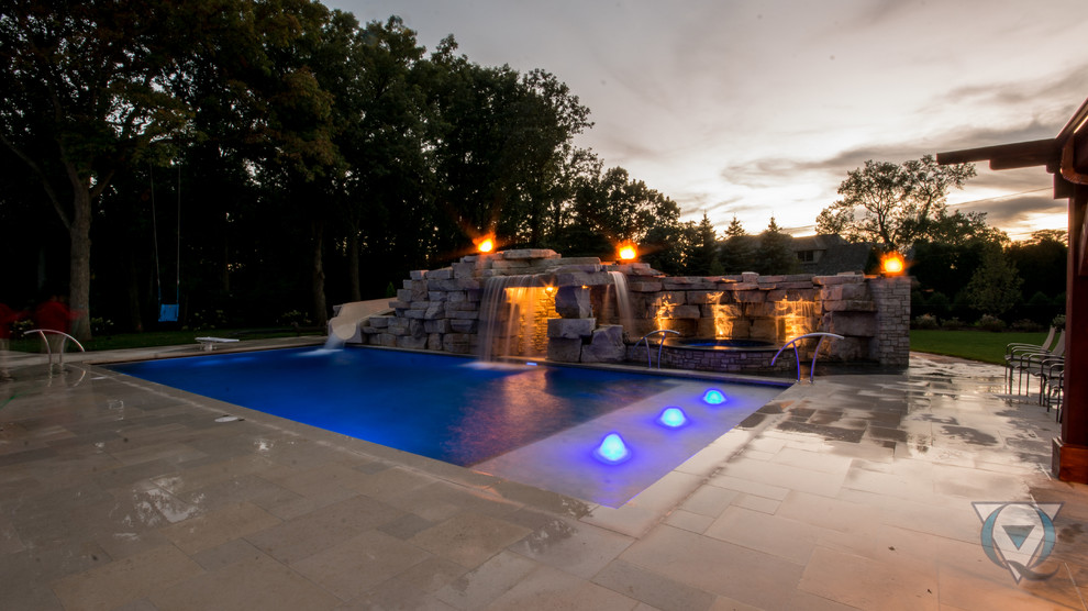 Example of a large mountain style backyard stone and rectangular natural pool fountain design in Chicago