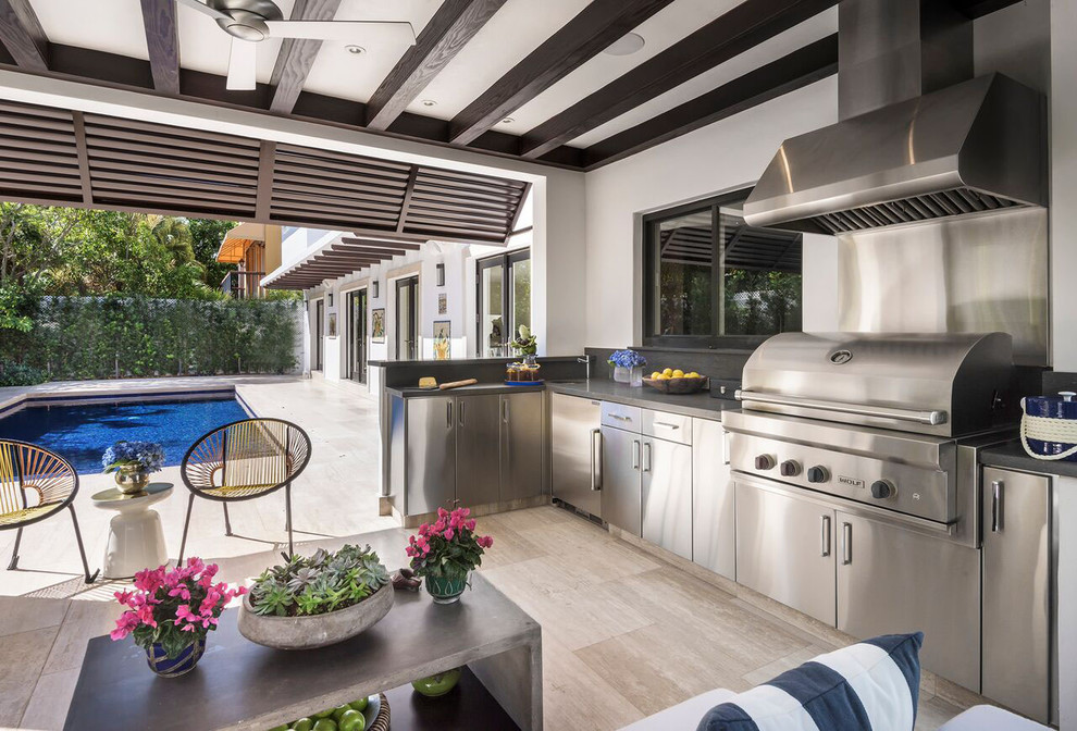 Mediterranean backyard patio in Miami with an outdoor kitchen, tile and a roof extension.