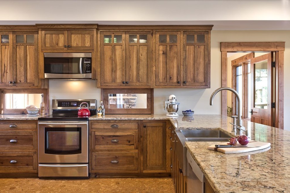 Inspiration for a mid-sized arts and crafts u-shaped eat-in kitchen in Other with a farmhouse sink, shaker cabinets, dark wood cabinets, granite benchtops, stainless steel appliances, cork floors, a peninsula and brown floor.