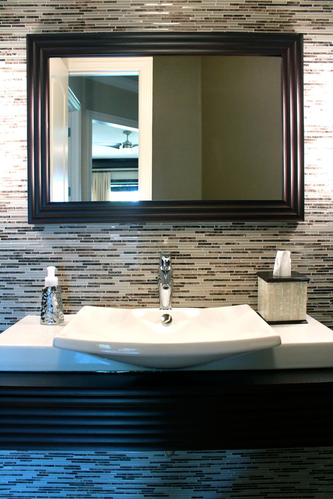 Small contemporary 3/4 bathroom in Dallas with a vessel sink, dark wood cabinets, a wall-mount toilet, brown tile, glass tile, beige walls and porcelain floors.