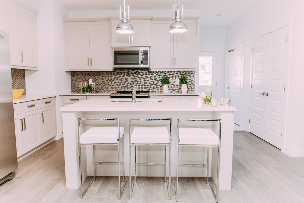 Design ideas for a small modern l-shaped eat-in kitchen in Edmonton with a double-bowl sink, shaker cabinets, white cabinets, quartz benchtops, grey splashback, glass tile splashback, stainless steel appliances, dark hardwood floors, with island and brown floor.