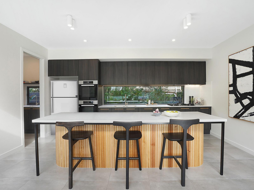 This is an example of a mid-sized contemporary eat-in kitchen in Brisbane with recessed-panel cabinets, glass sheet splashback, with island and grey floor.