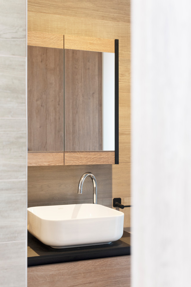 Example of a mid-sized trendy master wood-look tile wood-look tile floor and single-sink walk-in shower design in Nancy with light wood cabinets, a wall-mount toilet, laminate countertops, black countertops and a floating vanity