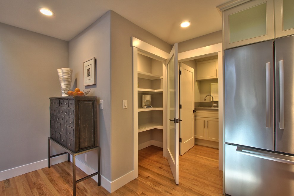Mid-sized transitional medium tone wood floor and beige floor kitchen pantry photo with shaker cabinets, white cabinets, stainless steel appliances and gray countertops