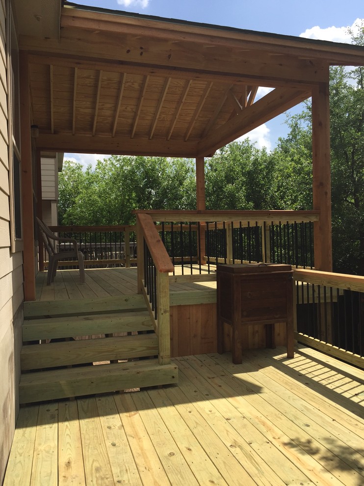 Inspiration for a mid-sized craftsman backyard deck remodel with a roof extension