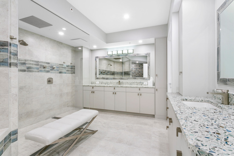 Photo of a transitional master bathroom in Miami with flat-panel cabinets, grey cabinets, a corner tub, an open shower, a one-piece toilet, grey walls, porcelain floors, an undermount sink, terrazzo benchtops, grey floor, an open shower, multi-coloured benchtops, a shower seat, a double vanity, a built-in vanity, multi-coloured tile and porcelain tile.