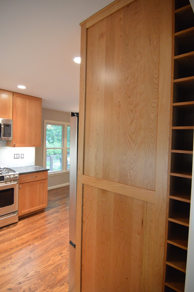 Enclosed kitchen - large transitional l-shaped medium tone wood floor enclosed kitchen idea in DC Metro with a single-bowl sink, shaker cabinets, light wood cabinets, granite countertops, white backsplash, glass tile backsplash, stainless steel appliances and no island