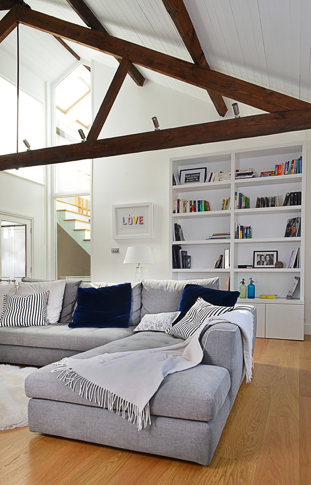 Inspiration for a contemporary formal open concept living room in London with light hardwood floors and white walls.