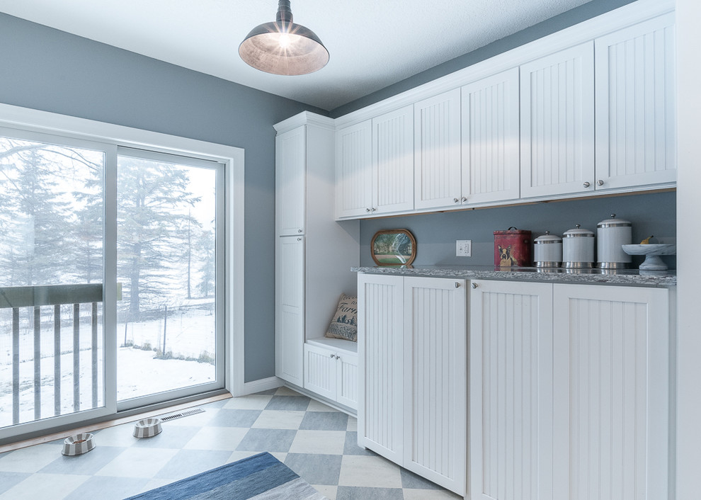 Design ideas for a country single-wall laundry room in Minneapolis with beaded inset cabinets, white cabinets, granite benchtops, blue walls, linoleum floors and a side-by-side washer and dryer.