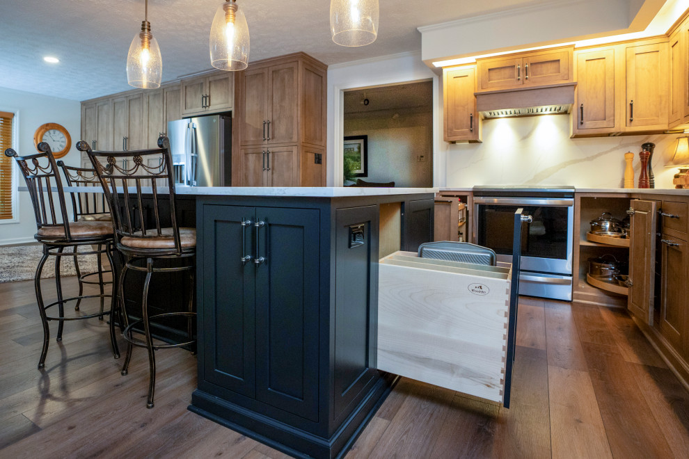 Inspiration for a large transitional l-shaped medium tone wood floor and brown floor eat-in kitchen remodel with a single-bowl sink, shaker cabinets, medium tone wood cabinets, quartz countertops, white backsplash, quartz backsplash, stainless steel appliances, an island and white countertops