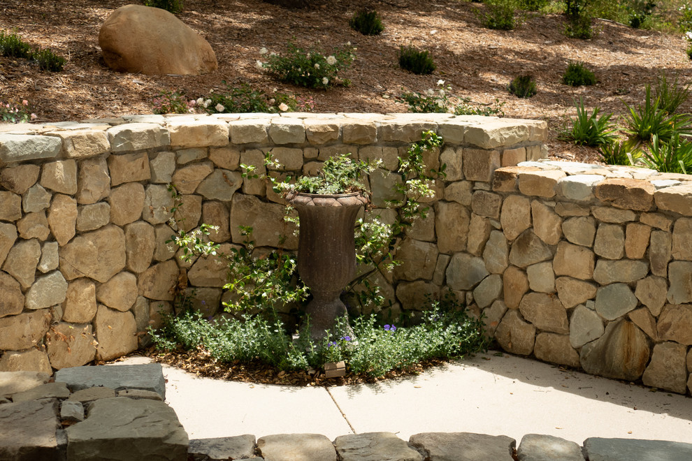 Inspiration for an arts and crafts sloped partial sun formal garden in Santa Barbara with a retaining wall.