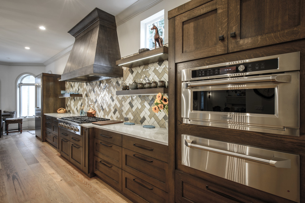 Example of a large transitional galley light wood floor kitchen design in Jacksonville with a double-bowl sink, shaker cabinets, dark wood cabinets, quartz countertops, brown backsplash, ceramic backsplash, stainless steel appliances and two islands