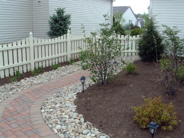 This is an example of a mid-sized traditional backyard partial sun formal garden for spring in Columbus with a garden path and brick pavers.
