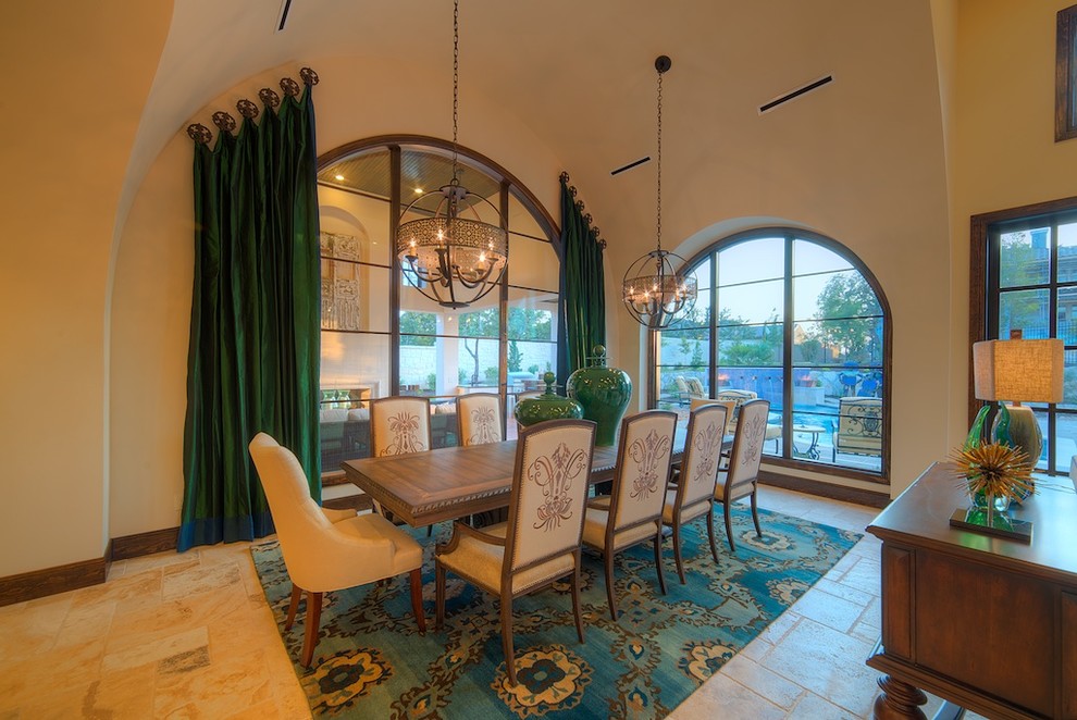 Photo of a large mediterranean separate dining room in Austin with beige walls, travertine floors and beige floor.