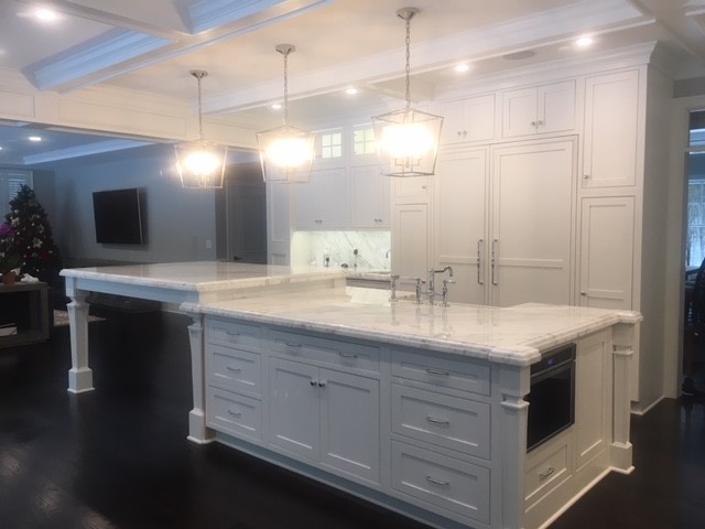 Open concept kitchen - large transitional l-shaped dark wood floor and brown floor open concept kitchen idea in Providence with a farmhouse sink, beaded inset cabinets, white cabinets, marble countertops, white backsplash, marble backsplash, paneled appliances, an island and white countertops