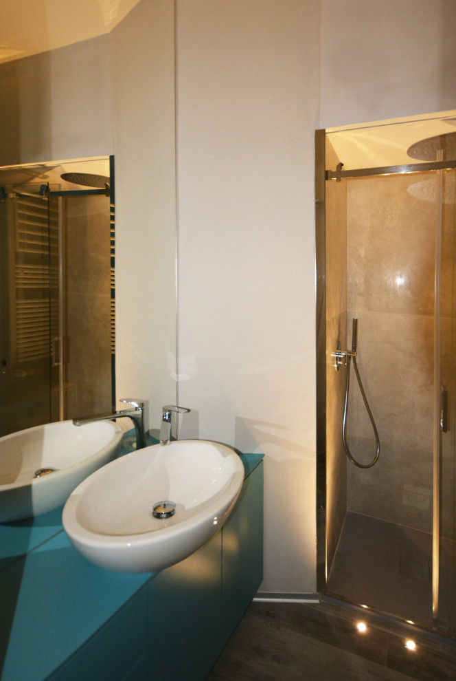 Идея дизайна: маленькая ванная комната в современном стиле с серыми фасадами, душем в нише, инсталляцией, керамогранитной плиткой, серыми стенами, полом из керамогранита, душевой кабиной, настольной раковиной, серым полом, душем с раздвижными дверями, бирюзовой столешницей, тумбой под одну раковину и подвесной тумбой для на участке и в саду