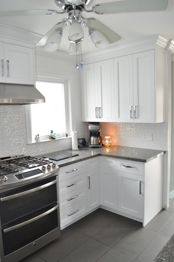 Example of a small transitional u-shaped porcelain tile and gray floor eat-in kitchen design in Toronto with an undermount sink, shaker cabinets, white cabinets, quartz countertops, white backsplash, porcelain backsplash, stainless steel appliances and an island