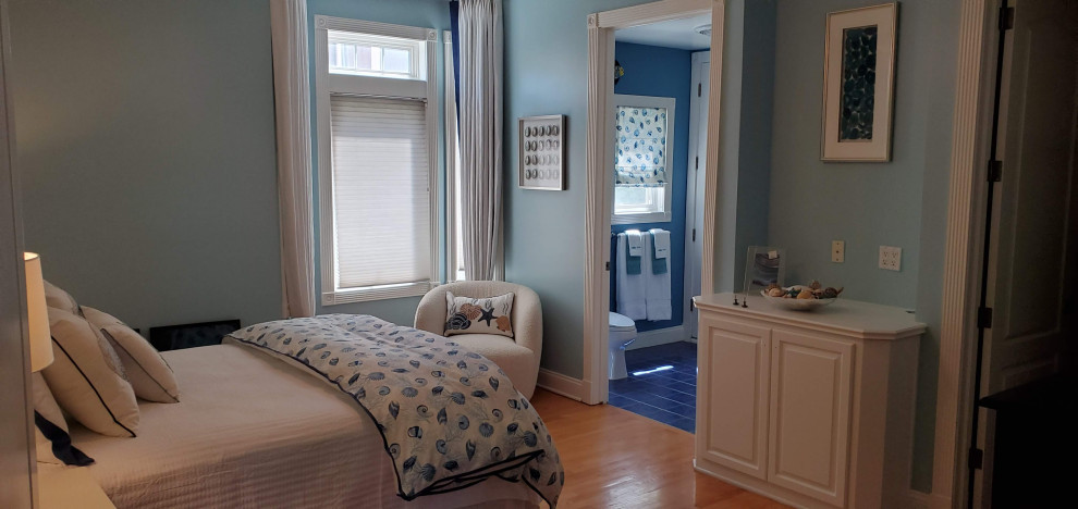 Photo of a mid-sized beach style guest bedroom in Los Angeles with blue walls, light hardwood floors and blue floor.