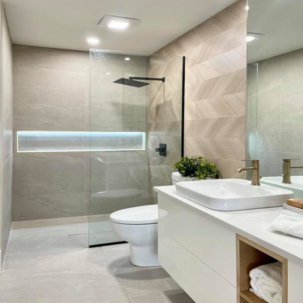 Photo of a mid-sized modern 3/4 bathroom in Vancouver with white cabinets, a curbless shower, a one-piece toilet, beige tile, ceramic tile, beige walls, porcelain floors, a drop-in sink, quartzite benchtops, grey floor, an open shower, white benchtops, a double vanity and a floating vanity.