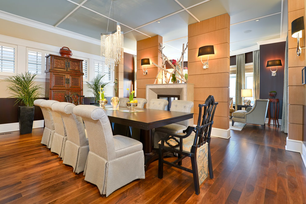Photo of a contemporary dining room in Chicago with beige walls, dark hardwood floors and a two-sided fireplace.