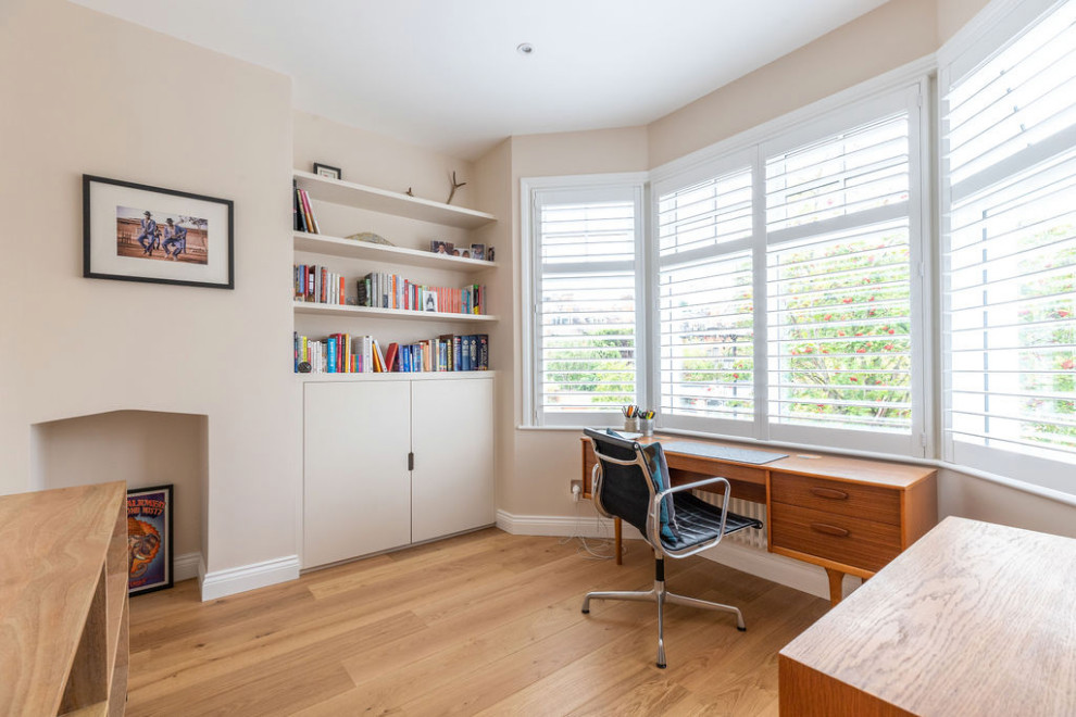 Ispirazione per un ufficio minimalista di medie dimensioni con pareti bianche, pavimento in legno massello medio, scrivania autoportante e pavimento marrone