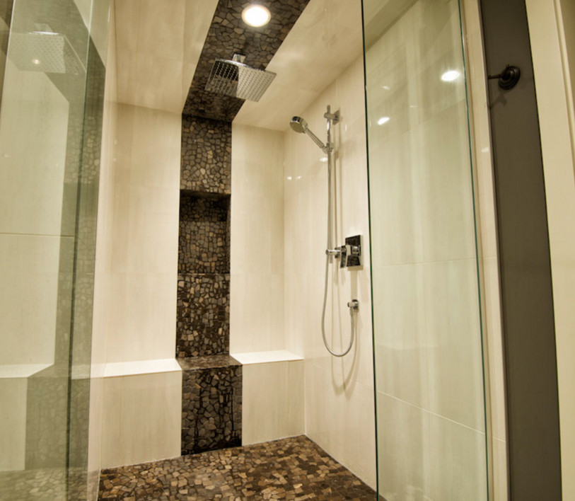 Large modern master bathroom in Calgary with black and white tile, pebble tile, grey walls and pebble tile floors.
