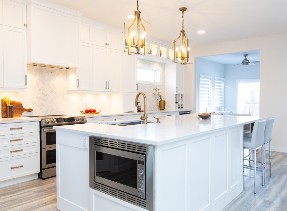 Open concept kitchen - large transitional l-shaped vinyl floor and gray floor open concept kitchen idea with an undermount sink, shaker cabinets, white cabinets, quartz countertops, white backsplash, marble backsplash, stainless steel appliances, an island and white countertops