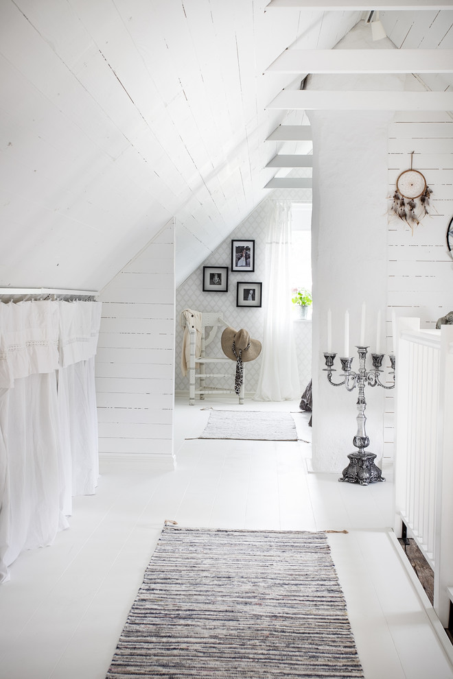 Small country hallway in Malmo with white walls, painted wood floors and white floor.