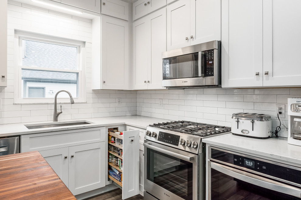 Eat-in kitchen - mid-sized transitional l-shaped eat-in kitchen idea in Columbus with shaker cabinets, quartz countertops, white backsplash, subway tile backsplash and an island