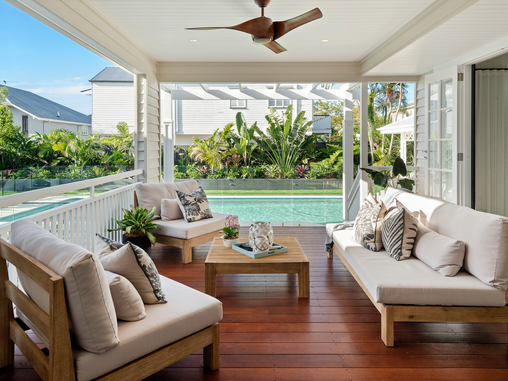 Design ideas for a mid-sized beach style backyard deck in Brisbane with a roof extension.