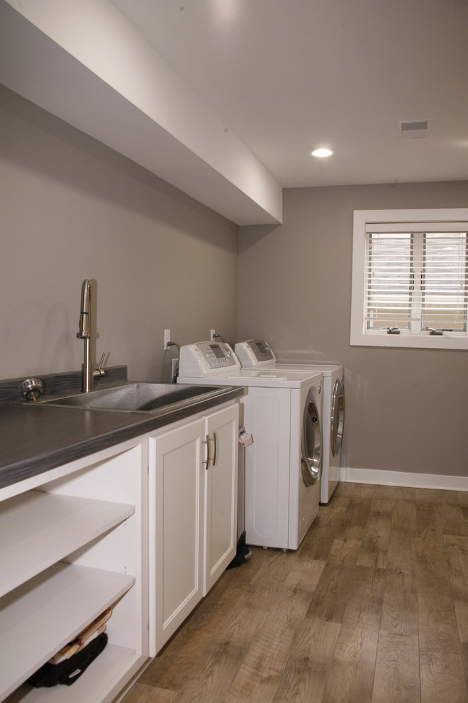 Contemporary laundry room in Grand Rapids with grey walls and vinyl floors.