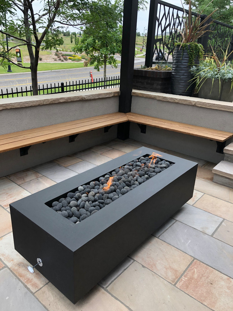 Mid-sized modern backyard garden in Denver with a fire feature and natural stone pavers.