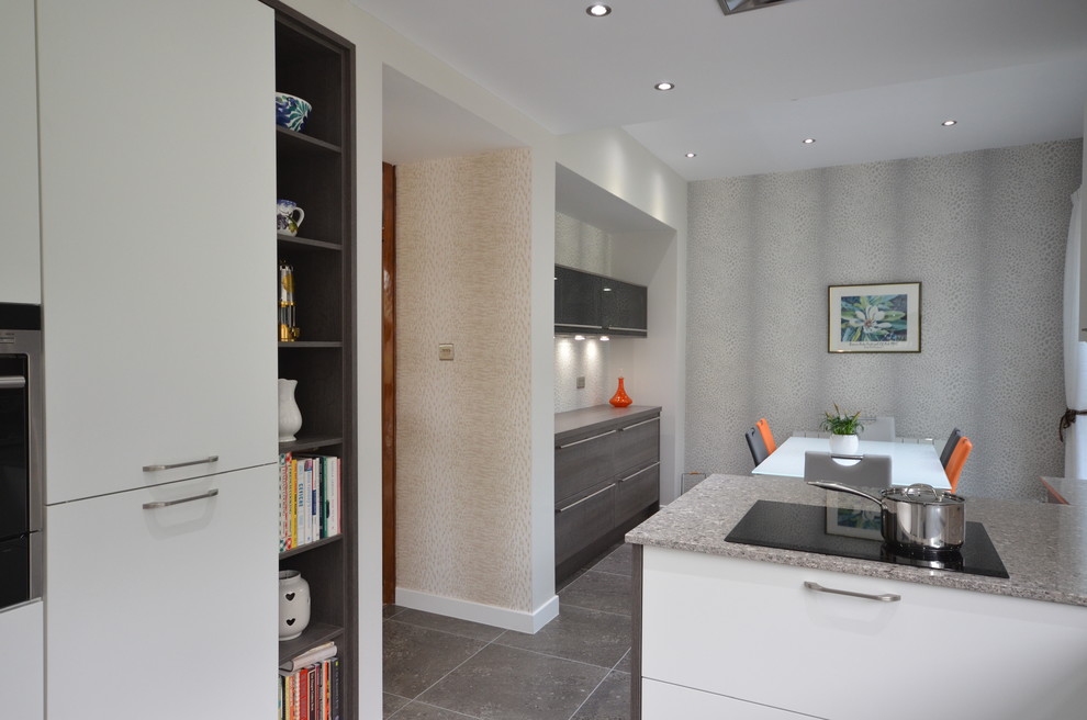 Mid-sized contemporary u-shaped eat-in kitchen in Glasgow with a double-bowl sink, open cabinets, grey cabinets, granite benchtops, grey splashback, marble splashback, coloured appliances, medium hardwood floors, no island and brown floor.