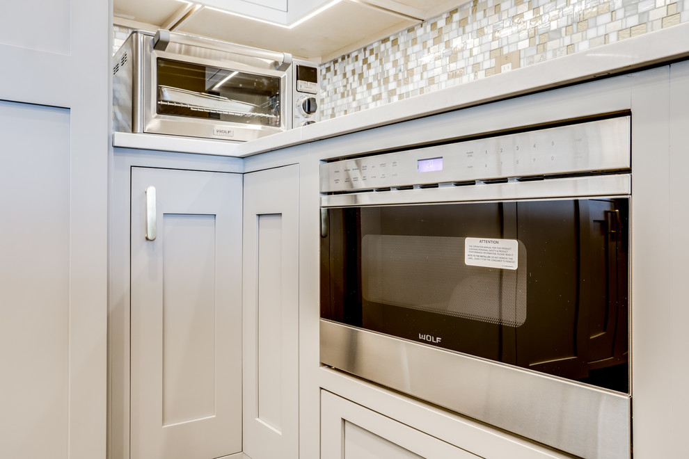 Large transitional enclosed kitchen photo in Baltimore with a farmhouse sink, mosaic tile backsplash, stainless steel appliances and an island