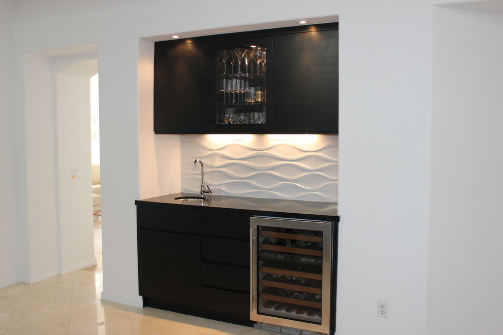 Photo of a small contemporary single-wall wet bar in Los Angeles with an undermount sink, flat-panel cabinets, black cabinets, quartz benchtops, white splashback, porcelain splashback and porcelain floors.