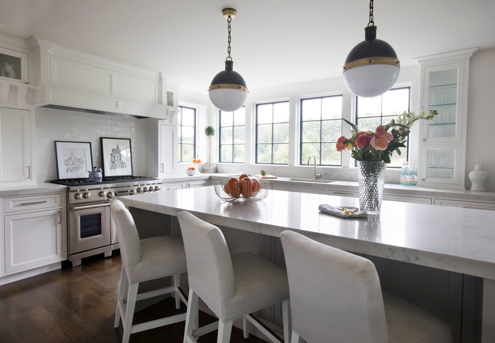 Design ideas for a transitional l-shaped kitchen in Boston with an undermount sink, shaker cabinets, white cabinets, white splashback, stainless steel appliances, dark hardwood floors and with island.
