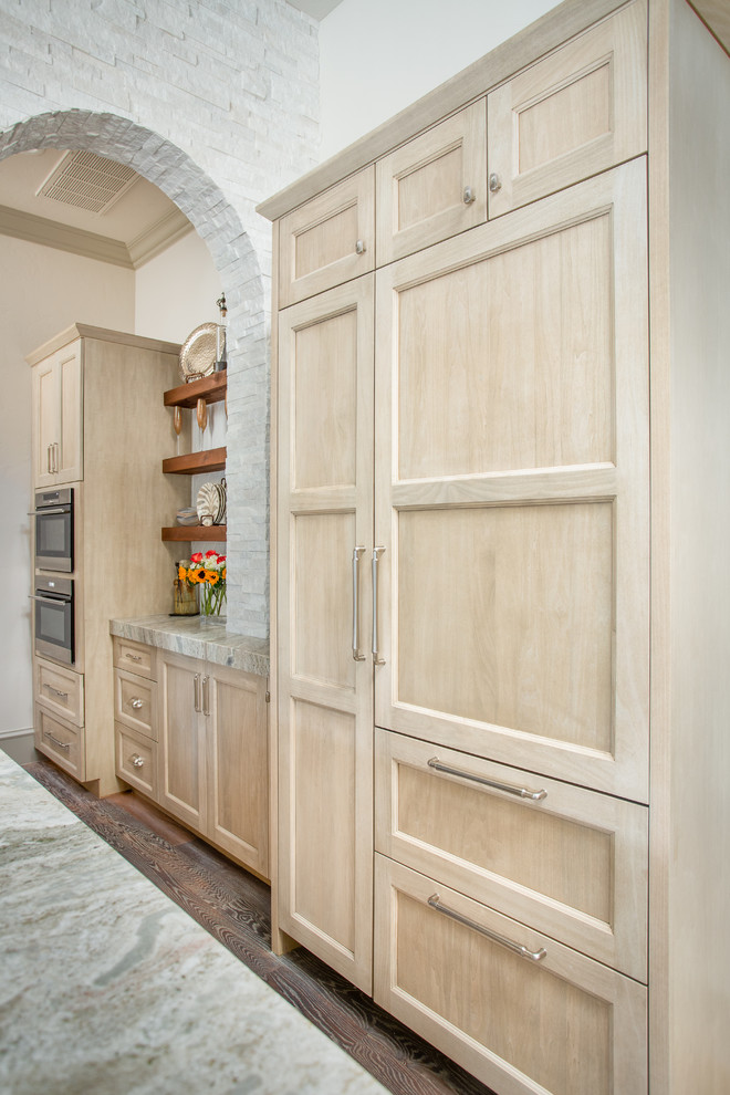 Mid-sized arts and crafts u-shaped kitchen pantry in Dallas with a farmhouse sink, recessed-panel cabinets, light wood cabinets, quartzite benchtops, white splashback, ceramic splashback, panelled appliances, medium hardwood floors, with island, brown floor and beige benchtop.